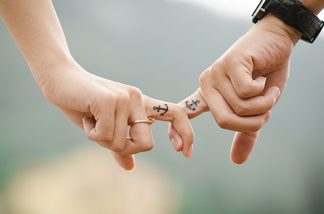 Couple holding fingers with nice tattoos
