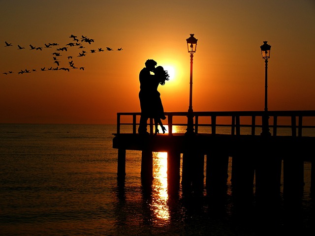 Love couple kiss each other while the sunset off