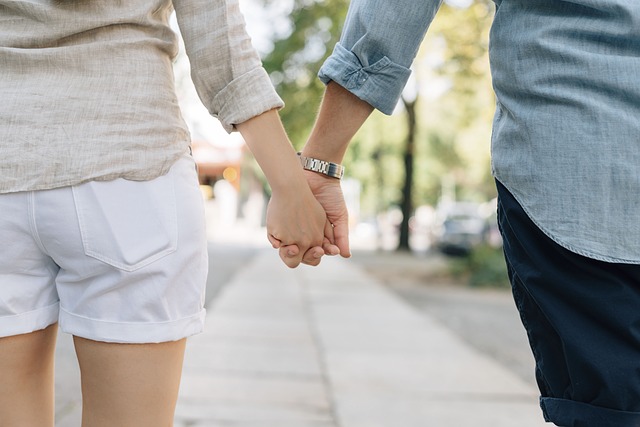 Love couple holding hands while walking in the street